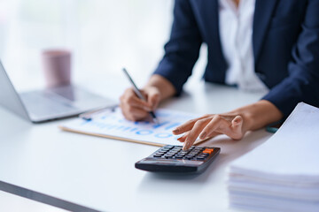 Close-up of the hands of a business woman using a calculator to check financial accounts check the company's expenses and budget.