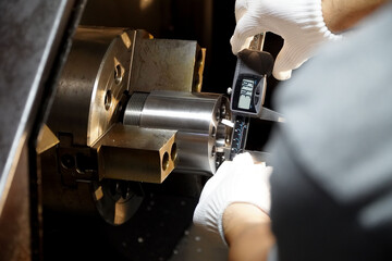 Quality control manufacturing.Hands of an engineer measures a metal part with a digital vernier...