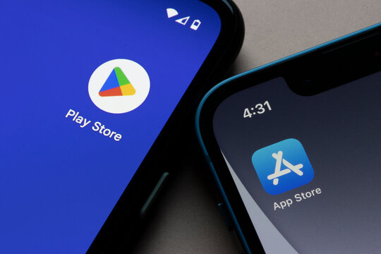 Portland, OR, USA - Nov 9, 2022: Icons of Google Play Store and Apple App Store are seen respectively on a Google Pixel smartphone and an iPhone. Google Play vs Apple App Store concept.