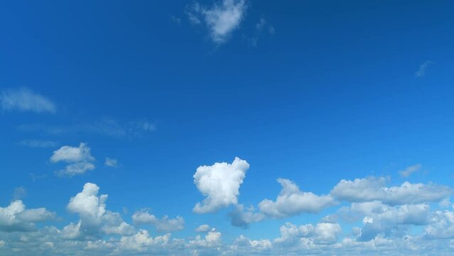 Summer clouds float across blue sky. Blue sky white clouds. Time lapse.