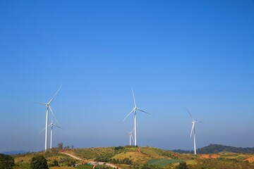 Landscape with hills and wind turbines and blue sky backgound.