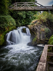Fototapeta na wymiar Waterfall under bridge in Washington state in summer