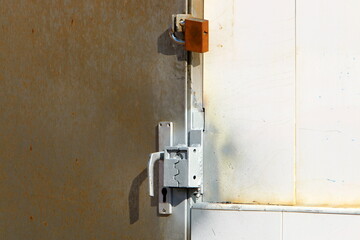 A rusty padlock hangs on a closed gate.