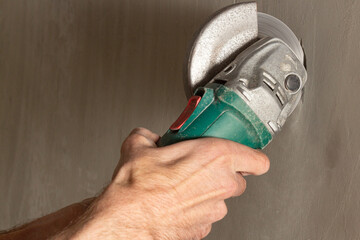 A construction worker cuts a concrete wall with a circular saw with a diamond crown.