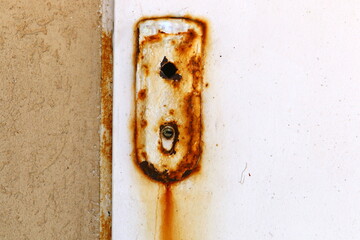 A rusty padlock hangs on a closed gate.