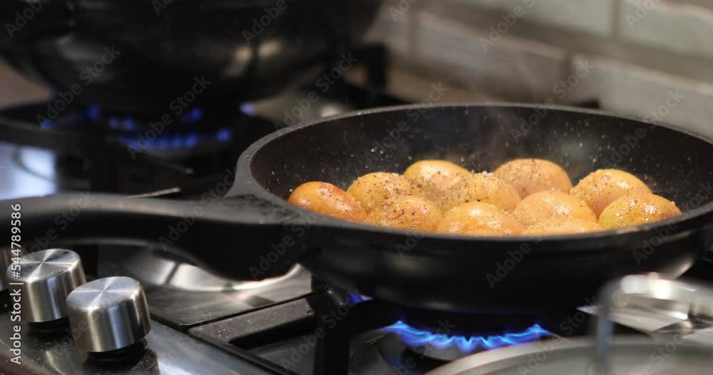 Poster Apricots are fried in pan on gas stove. Chef sprinkles apricots with sugar