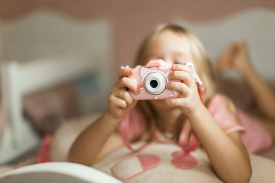 little girl taking pictures with her pink camera