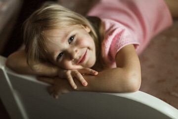 little girl lies on her bed in the children's room