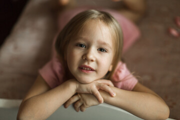 little girl lies on her bed in the children's room