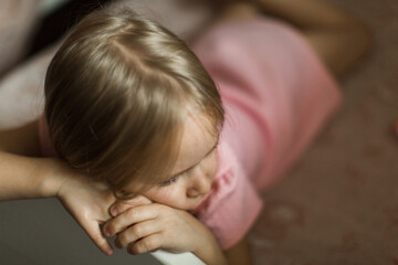 little girl lies on her bed in the children's room