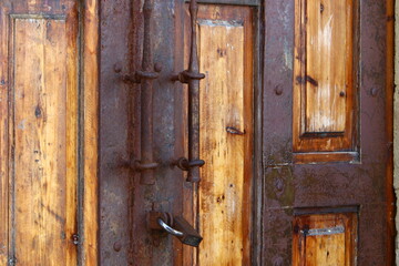 A rusty padlock hangs on a closed gate.