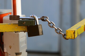 A rusty padlock hangs on a closed gate.