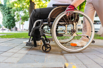 Fototapeta na wymiar Unrecognizable woman with disability sitting in wheelchair in the street close up
