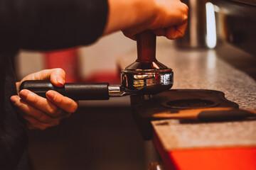 holder in the female hands of a barista in a coffee shop, making coffee, the process