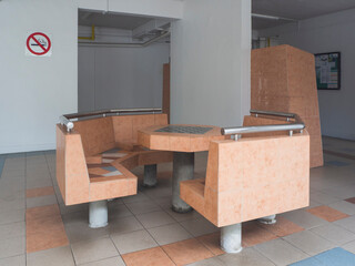 Public seating area with a chess table at the void deck of a block of HDB flats in a residential neighbourhood.