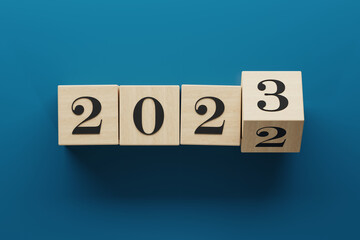2023 wooden cube blocks flipping to change from 2022. Transition and new year theme. 3d rendering illustration blue.