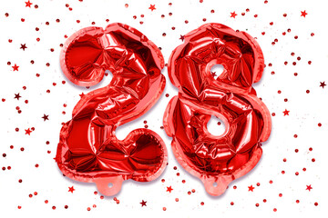 The number of the balloon made of red foil, the number twenty-eight on a white background with sequins. Birthday greeting card with inscription 28. Numerical digit, Celebration event.