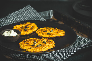 Baked pumpkin fritters served with sour cream