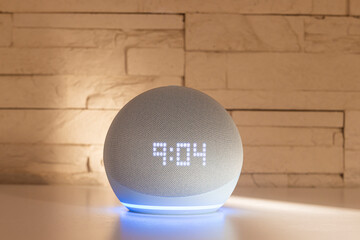 Voice controlled speaker with activated voice recognition, on brick background.