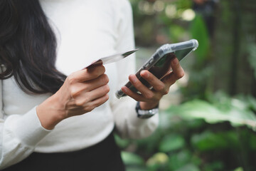 Concept of mobile banking. A Female Freelance client hold mobile phone credit bank card do online shopping provide internet payment. A woman enjoy easy fast transferring money in ebank application.