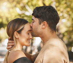 Fototapeta premium Kiss, love and romance with a couple bonding outdoor during a date on a summer day. Happy, trust and smile with a young man and woman kissing outside together while dating or being romantic