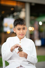 Asian boy play Ching finger cymbals played in Cambodian and Thai theater and dance ensembles