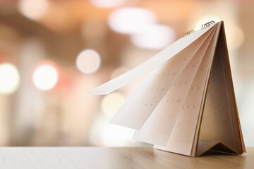 desk calendar on table with blurred bokeh background appointment and business meeting concept