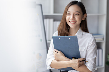 Young business Asian woman holding document file and stand in home office