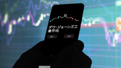 投資家が携帯電話で ダウ・ジョーンズ工業平均 ETF を分析している...