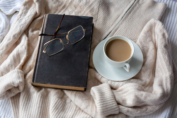 Book with mug of cocoa on white with beige background