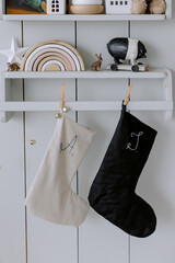 New Year's socks for gifts in black and white colors hang on a children's wooden shelf