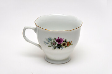 Empty ceramic cup with floral pattern on white background
