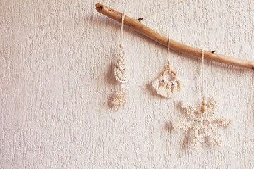 Christmas macrame decor. Christmas snowflake and decorative elements on wooden stick. Natural materials - cotton thread, wood beads. Eco decorations, ornaments, hand made decor. Copy space