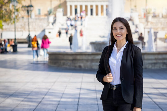 A Greek, professional business woman in corporate outfit standing on the Syntagma Square in Athens, Greece