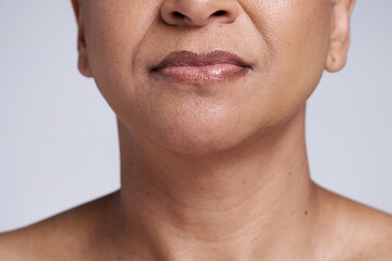 Beauty, skincare and lips of senior woman isolated in studio for wellness, healthy and natural...
