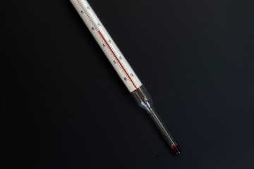 mercury thermometer, 56 degrees Celsius, on a isolated black background