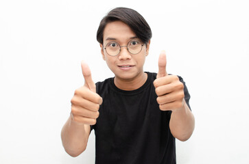 handsome attractive Asian man smiling happily and giving thumbs up as compliment isolated over...
