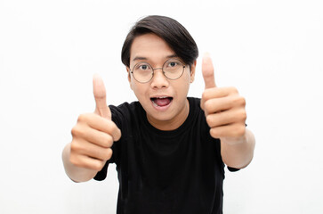 handsome attractive Asian man smiling happily and giving thumbs up as compliment isolated over...