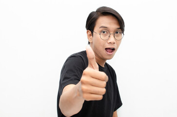 handsome attractive Asian man smiling happily and giving thumbs up as compliment isolated over...