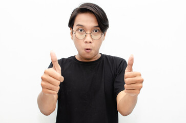 handsome attractive Asian man smiling happily and giving thumbs up as compliment isolated over...