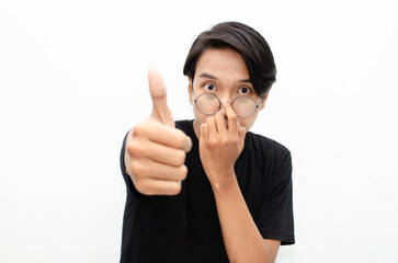 handsome attractive Asian man smiling happily and giving thumbs up as compliment isolated over white background. man giving approval and compliment by gesturing thumbs up.