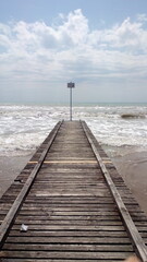 wooden jetty on covered by clouds beach