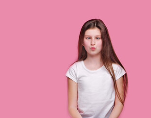 Obraz premium Brunette girl in a pink studio gets crossed eyes as a joke