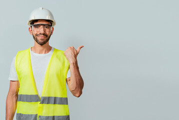 Portrait of engineer man pointing aside. Construction worker with vest pointing at an...