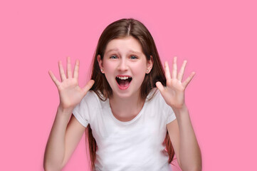 Scared teen girl screaming of fear isolated on pink