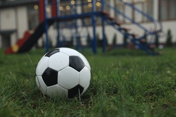 Fototapeta na wymiar Wet leather soccer ball on grass outdoors, space for text