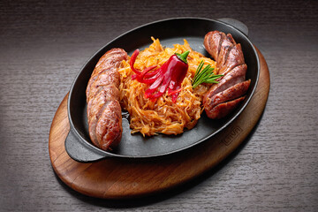 Fried sausages with stewed cabbage in a pan