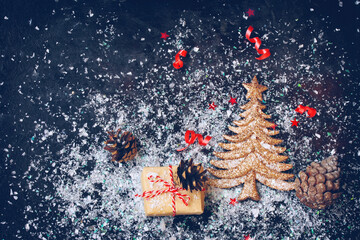 dark christmas background with golden fir tree, snow, gift box