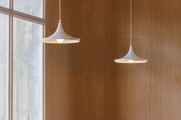 white hanging steel lamp on wooden wall background.