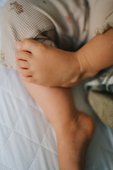 Baby feet taking a nap with brown sheets. Relax, lifestyle concept. Rest concept. People lifestyle concept. Happiness concept. Child health care. Skin care.